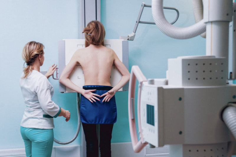 Radiologo e paziente in una stanza di ospedale per svolgere una radiografia tramite un sistema radiografico a soffitto 
