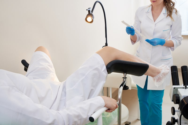 Ginecologa esegue tampone vaginale ad una donna sdraiata su un lettino di uno studio medico