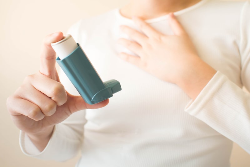 Primo piano del farmaco per l'asma tenuto in mano da un paziente