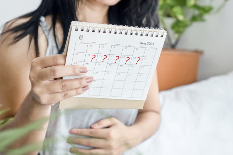 Donna che tiene in mano un calendario con delle croci rosse sui giorni che segnano l'assenza di mestruazioni dettata dall'amenorrea