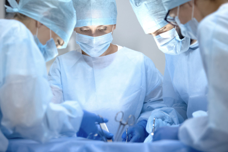 Primo piano di un equipe di chirurgi in sala operatoria mentre svolgono un intervento toracico in laparoscopia