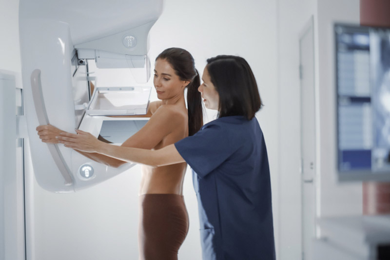 Dottoressa spiega la procedura di mammografia a una paziente adulta sottoposta a scansione mammografica in una sala di ospedale 