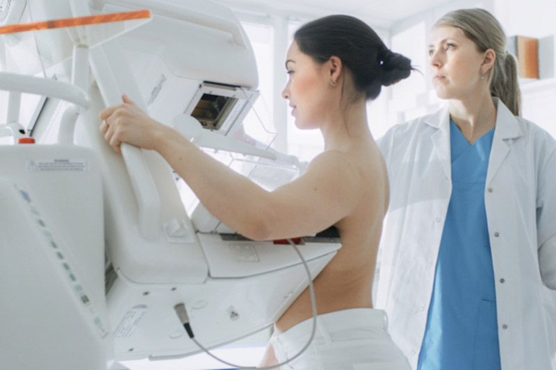 Foto in una sala di ospedale medico sottopone una paziente donna allo screening mammografico per prevenire il cancro al seno