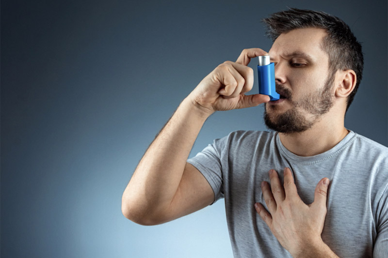 Uomo adulto usa un broncodilatatore per l'asma