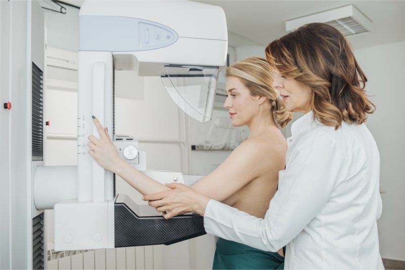 Donna assistita da un medico mentre svolge una mammografia in un centro specializzato