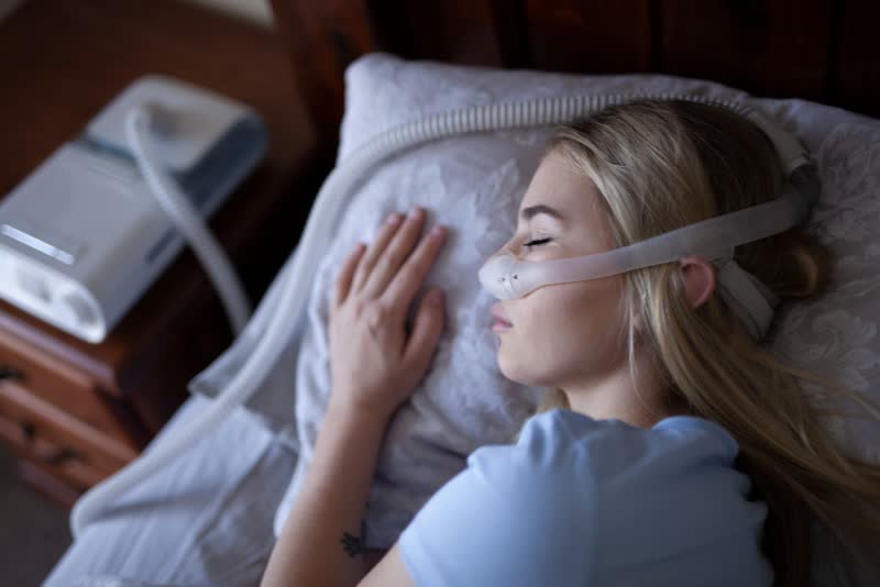 Foto di donna che dorme con apparecchio CPAP per facilitare la respirazione